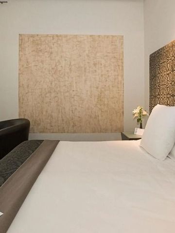 Luxus-Doppelbett in modernem Zimmer mit kunstvoller Wandgestaltung