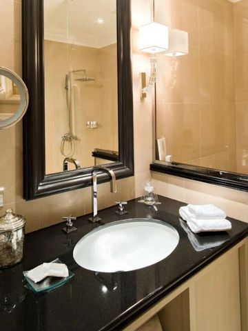 Badezimmer mit edel gestaltetem Waschbereich und großem Spiegel