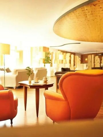 Luxuriöse Lounge mit orangen Sesseln und moderner Einrichtung