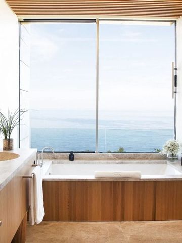 Luxuriöses Badezimmer mit freistehender Wanne und Meerblick