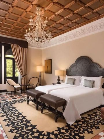 Hotelzimmer mit zwei Einzelbetten, stilvollem Dekor und Kronleuchter