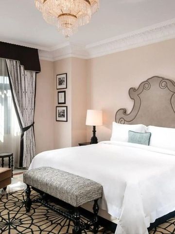 Geräumiges Zimmer mit großem Bett, eleganter Beleuchtung und Sitzbereich