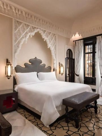 Luxuriös dekoriertes Zimmer mit aufwendigen Mustern und einem großen Bett