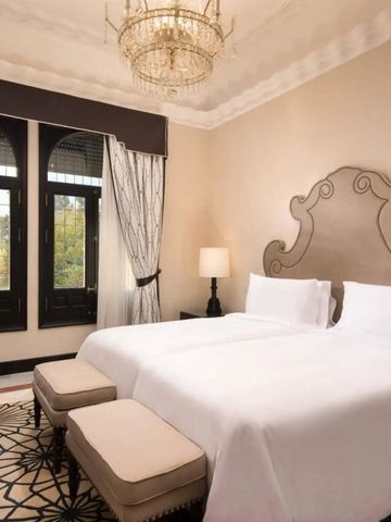 Elegantes Schlafzimmer mit zwei Einzelbetten und Kronleuchter im Hotel Alfonso XIII