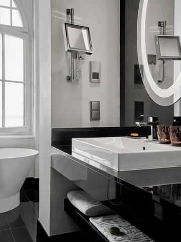 Modernes Badezimmer mit Badewanne und beleuchtetem Spiegel