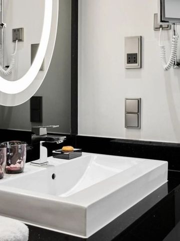 Elegantes Badezimmer mit großem beleuchtetem Spiegel und Waschbecken