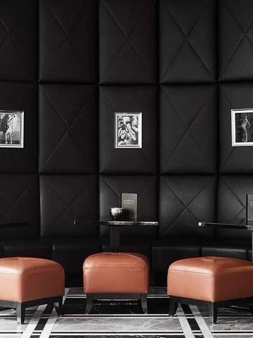 Luxuriöser Lounge-Bereich mit Lederhockern und gepolsterter Wandverkleidung