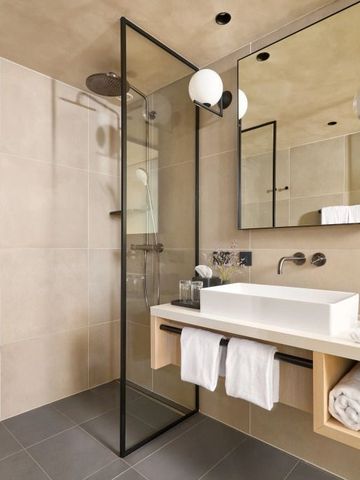 Schickes Badezimmer mit Glasdusche und modernen Armaturen