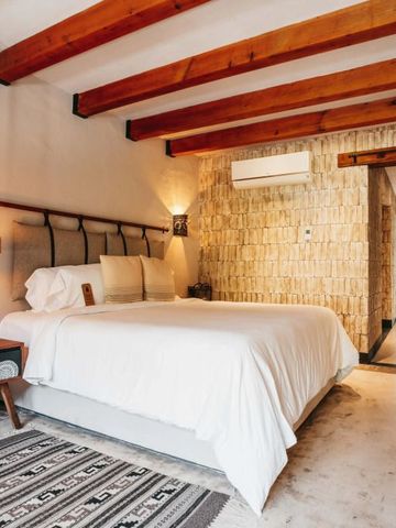 Einladendes Doppelzimmer mit Holzbalkendecke und Steinakzenten