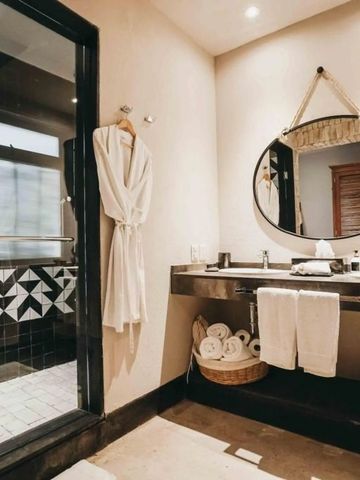 Luxuriöses Badezimmer mit Rundspiegel und Bademantel