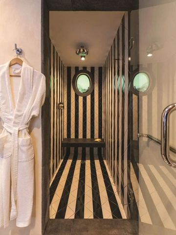 Elegante Duschkabine in Schwarz-Weiß mit luxuriösem Bademantel