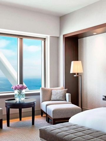 Hotelzimmer mit Blick auf das Meer durch ein großes Fenster und eleganter Einrichtung.