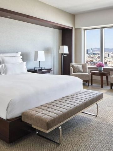 Geräumiges Hotelzimmer mit Panoramaausblick über die Stadt, elegant möbliert.