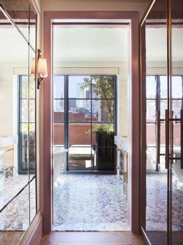 Luxuriöses Badezimmer mit Zugang zu einem Balkon und urbanem Ausblick