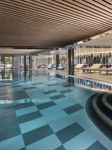 Luxuriöser Innenpool mit Mosaikfliesen und gemütlichen Liegen