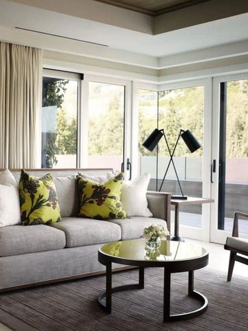 Lichtdurchflutetes Wohnzimmer mit moderner Einrichtung und Blick auf die Bäume