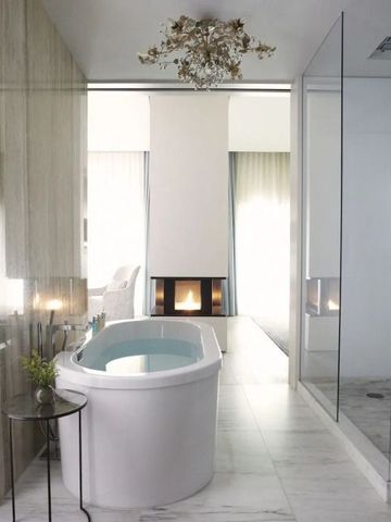 Luxuriöses Badezimmer mit freistehender Badewanne und Kamin