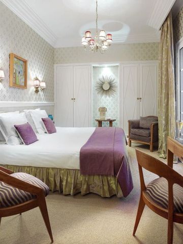 Komfortables Gästezimmer mit Doppelbett und klassischer Dekoration