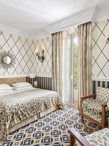 Komfortables Hotelzimmer mit modernem Dekor und großem Bett nahe Fenster.