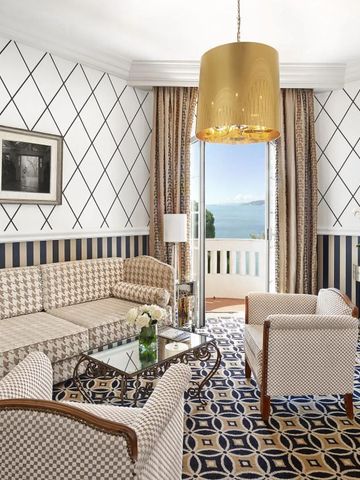 Helles Wohnzimmer mit eleganten Möbeln und Blick auf den Balkon mit Meerblick.