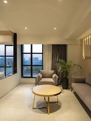 Elegantes Wohnzimmer einer Hotelsuite mit großer Fensterfront und moderner Einrichtung