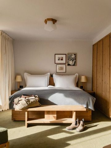 Helles Hotelzimmer mit Doppelbett, Holzdetails und großem Fenster