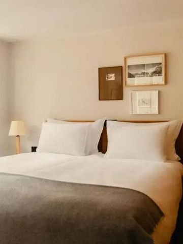 Doppelbett in stilvollem Zimmer mit minimalistischer Dekoration