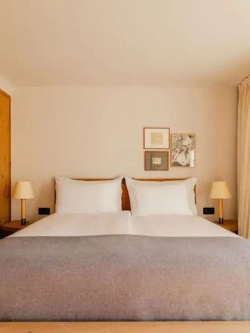 Zimmer mit Doppelbett, Holzmöbeln und sanften neutralen Tönen