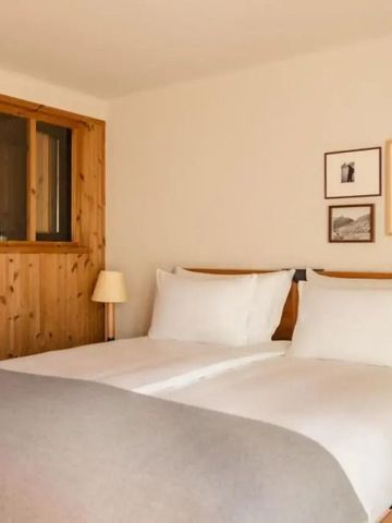 Gemütliches Doppelzimmer mit Holzwänden und moderner Einrichtung