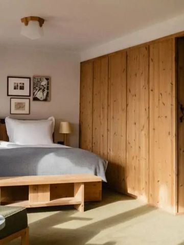 Helles Schlafzimmer mit Holzmöbeln und großem Bett in einem Hotelzimmer