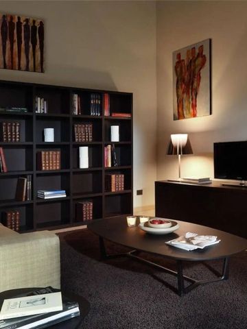 Gemütliche Lounge mit Bücherregal und moderner Kunst an der Wand