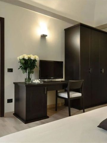 Elegantes Hotelzimmer mit Schreibtisch, Stuhl und großem Kleiderschrank