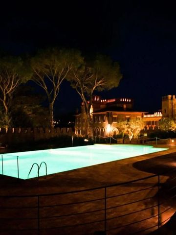 Beleuchteter Außenpool bei Nacht mit umliegenden Bäumen