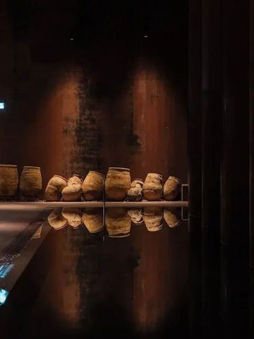 Gedämpft beleuchteter Raum mit traditionellen Elementen und Spiegelungen.