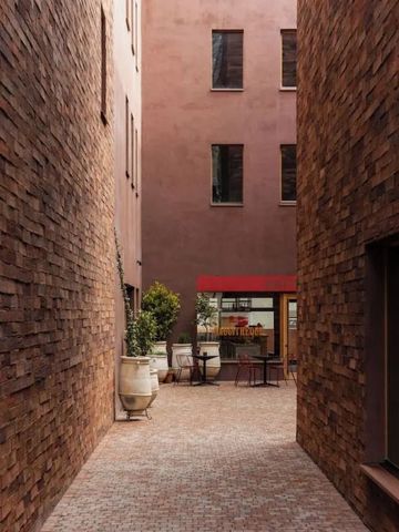 Außenbereich mit roten Backsteinwänden und Terrasse mit Pflanzen