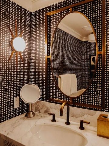 Badezimmer mit stilvollem Spiegel und exklusiven Wandleuchten