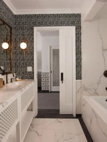 Großes Badezimmer mit Marmorwand und entspannender Badewanne