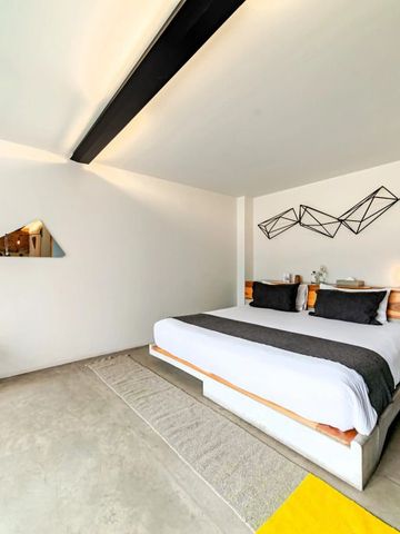 Modernes Zimmer mit großem Bett und stilvoller Wanddekoration im Hotel Carlota