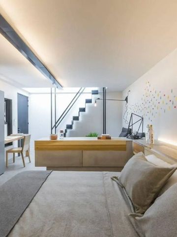 Modern eingerichtetes Hotelzimmer mit Treppe im Hintergrund