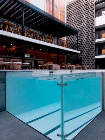 Moderner Pool mit Glaswänden und Terrasse im Hintergrund