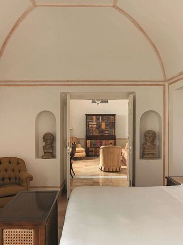 Elegantes Hotelzimmer mit luxuriöser Einrichtung und antiken Büsten.