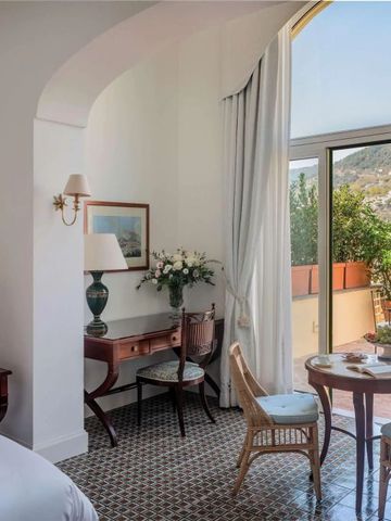 Helles Zimmer mit Balkonblick auf die Amalfi-Küste und stilvollen Möbeln.