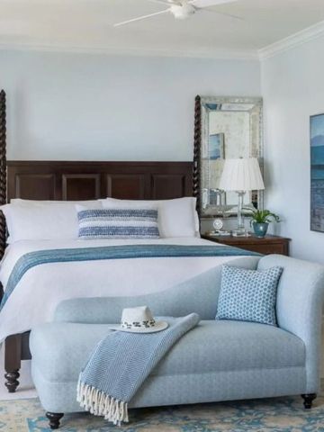 Helles Hotelzimmer mit Kingsize-Bett und blauer Couch, elegant eingerichtet.