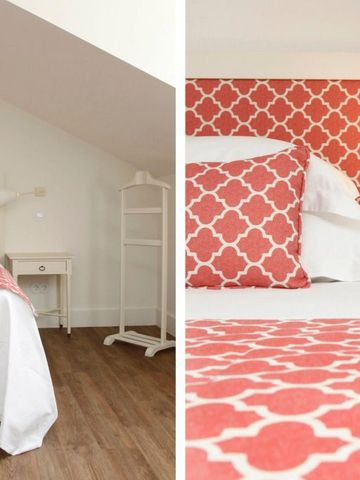 Zimmer mit auffälligem rot-weißem Bettbezug und modernem Design