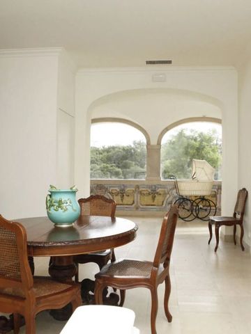 Heller Essbereich mit antikem Tisch und Blick auf einen Garten im Hotel Casa Palmela