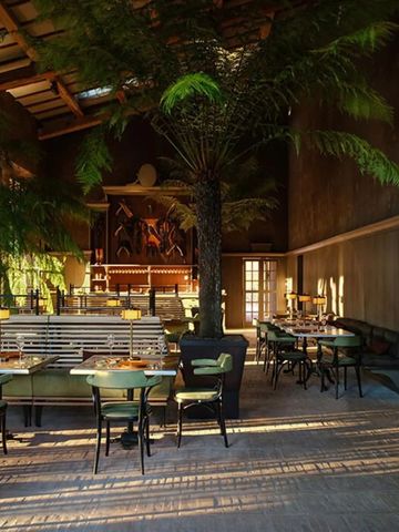 Elegantes Restaurant mit hohen Decken und üppigen Pflanzen