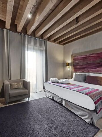 Luxuriöses Hotelzimmer mit Holzbalken an der Decke und modernen Möbeln im Hotel Castilla Termal Monasterio de Valbuena.