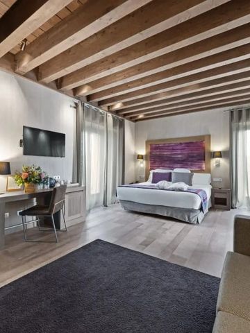 Geräumiges Zimmer mit Holzbalkendecke und moderner Dekoration im Hotel Castilla Termal Monasterio de Valbuena.