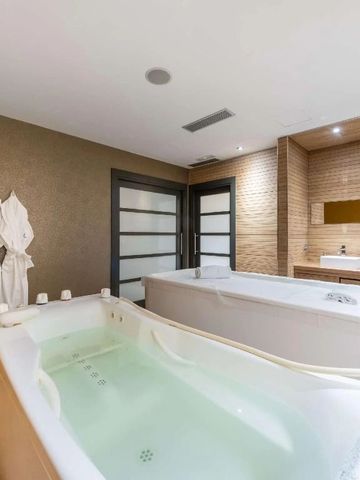 Luxuriöses Badezimmer mit zwei Whirlpool-Badewannen und moderner Ausstattung.