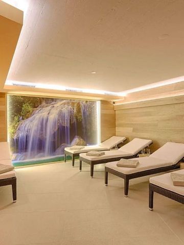 Wellnessbereich mit Liegen und großem Wasserfallbild